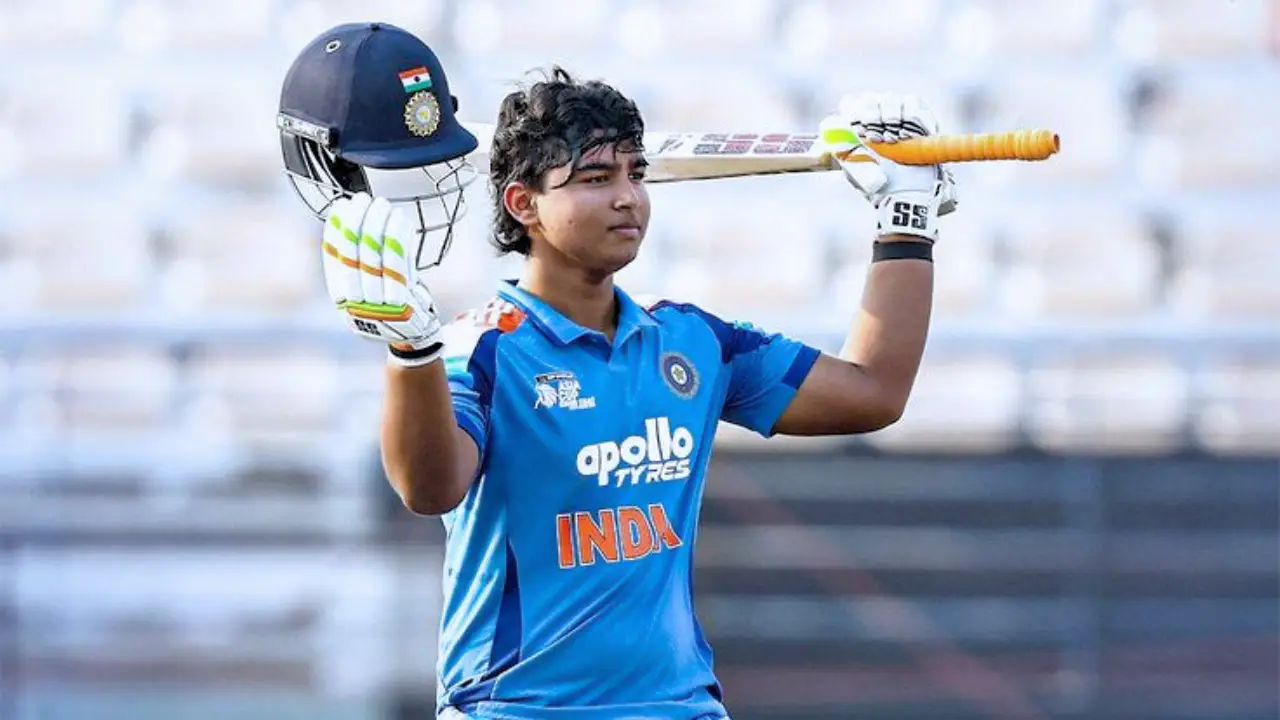 Young Indian cricketer raising bat and helmet in celebration after reaching a milestone